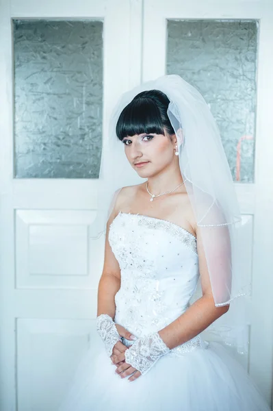 Όμορφη νύφη ετοιμάζεται σε άσπρο γαμήλιο φόρεμα με χτένισμα και φωτεινό μακιγιάζ. Ευτυχισμένος σέξι κορίτσι σας περιμένουν για γαμπρό. Ρομαντική κυρία στο νυφικό φόρεμα έχουν τελική προετοιμασία για το γάμο. — Φωτογραφία Αρχείου