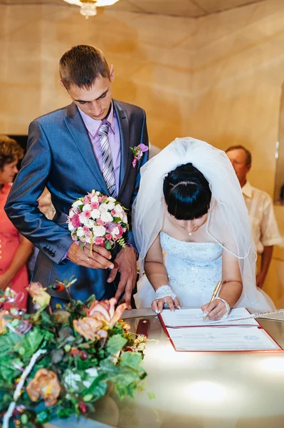 Ceremonia de boda. Oficina de registro. Una pareja de recién casados firma el documento de matrimonio.Pareja joven firma documentos de boda . —  Fotos de Stock