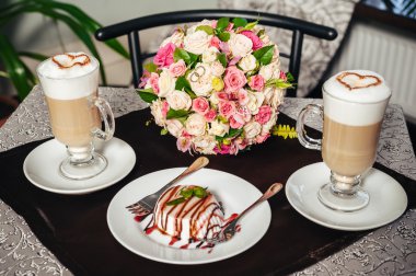 Gelin ve damat elleri. Cappuccino veya kalp şekli ile kahve latte. Gelin ve damat bir fincan kahve latte tarihini iç. Mutlu gelin ve damat bir fincan kahve latte kalp tasarımı ile içmek