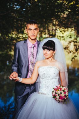 Gelin ve damat, düğün günü açık havada yürüyüş Doğa bahar. mutlu yeni evli kadın ve erkek yeşil park kucaklayan gelin çift. sevgi dolu evlilik çift açık