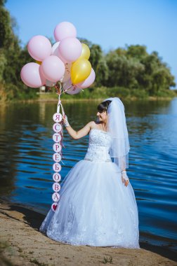 Büyük renkli lateks balonlar sahil üzerinde mutlu genç kızla. Güzellik romantik kız açık havada. Mavi gökyüzü arka plan üzerinde bir elektrik direği eğleniyor uzun sarı dalgalı saçlı kadın.