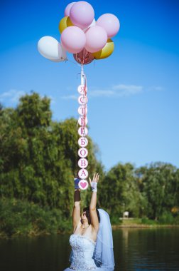 Büyük renkli lateks balonlar sahil üzerinde mutlu genç kızla. Güzellik romantik kız açık havada. Mavi gökyüzü arka plan üzerinde bir elektrik direği eğleniyor uzun sarı dalgalı saçlı kadın.