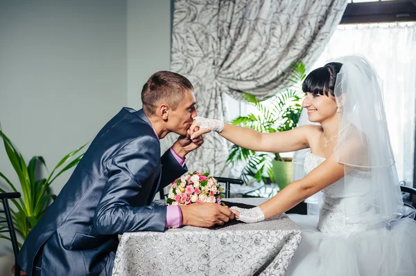 Encantadores novios en la celebración de su boda en un lujoso restaurante. Pareja cariñosa en fecha —  Fotos de Stock