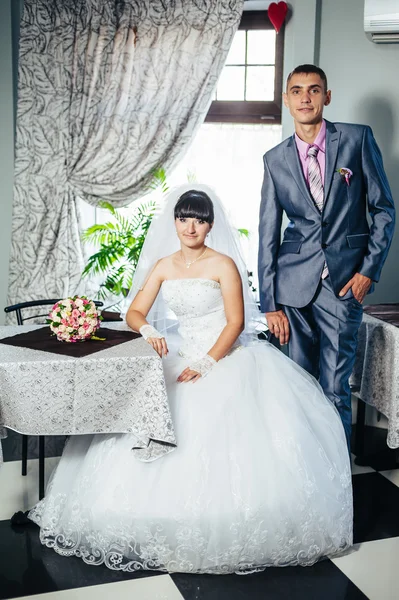 Encantadores novios en la celebración de su boda en un lujoso restaurante. Pareja cariñosa en fecha —  Fotos de Stock