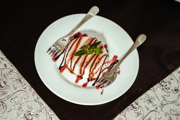 Italian dessert panna cotta served on a white plate with chocolate sauce and fresh mint — Stock Photo, Image