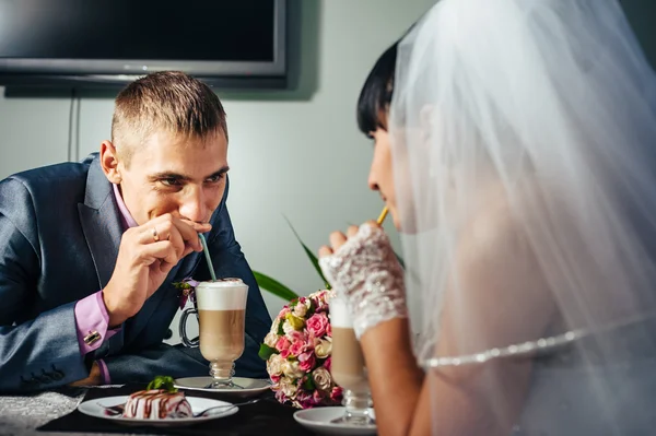 Encantadores novios en la celebración de su boda en un lujoso restaurante. Pareja cariñosa en fecha — Foto de Stock