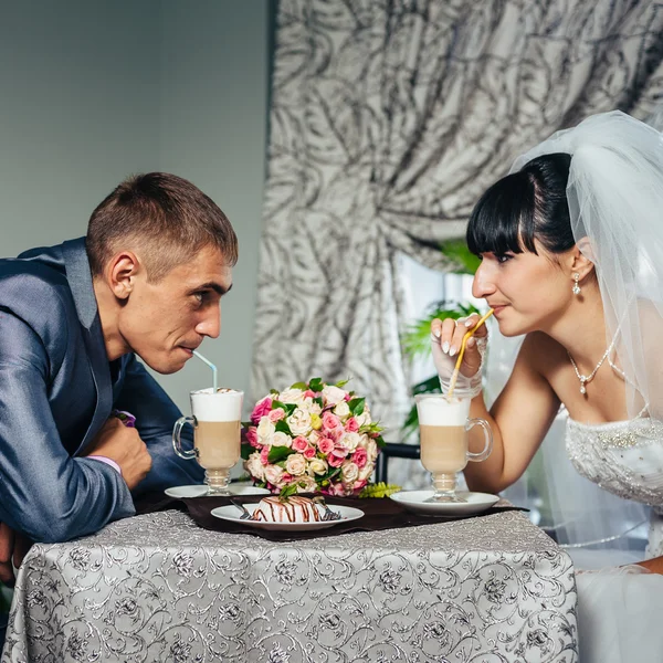 Encantadores novios en la celebración de su boda en un lujoso restaurante. Pareja cariñosa en fecha —  Fotos de Stock