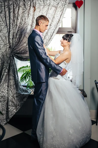 Encantadores novios en la celebración de su boda en un lujoso restaurante. Pareja cariñosa en fecha —  Fotos de Stock