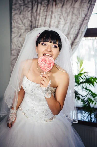 Retrato de una joven novia con una piruleta de caramelo en forma de corazón —  Fotos de Stock