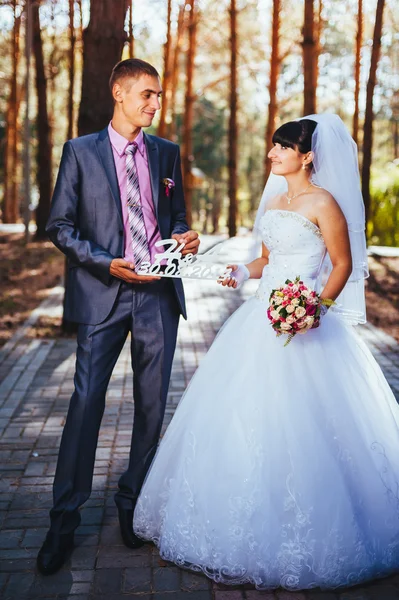 結婚式の日に屋外歩行で、新郎新婦自然を春します。ブライダル カップル、幸せな新婚男女緑豊かな公園を受け入れます。屋外の結婚式のカップルを愛してください。 — ストック写真