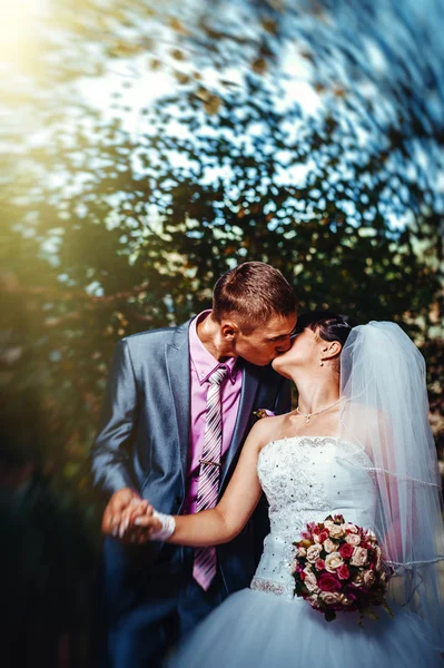 Novia y novio en el día de la boda caminando al aire libre en la naturaleza de primavera. Pareja nupcial, feliz mujer recién casada y hombre abrazándose en el parque verde. Amar pareja de boda al aire libre — Foto de Stock