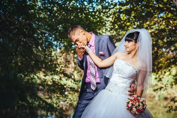 結婚式の日に屋外歩行で、新郎新婦自然を春します。ブライダル カップル、幸せな新婚男女緑豊かな公園を受け入れます。屋外の結婚式のカップルを愛してください。 — ストック写真