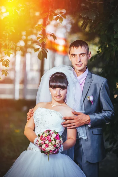 Novia y novio en el día de la boda caminando al aire libre en la naturaleza de primavera. Pareja nupcial, feliz mujer recién casada y hombre abrazándose en el parque verde. Amar pareja de boda al aire libre —  Fotos de Stock