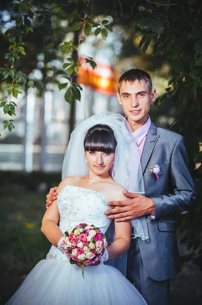 Νύφη και γαμπρός στο περπάτημα σε εξωτερικούς χώρους για την ημέρα του γάμου άνοιξη φύση. νυφικό ζευγάρι, γυναίκα ευτυχισμένη νεόνυμφο και άνθρωπος, αγκαλιάζοντας σε καταπράσινο πάρκο. αγαπώντας το γαμήλιο ζεύγος εξωτερική — Φωτογραφία Αρχείου