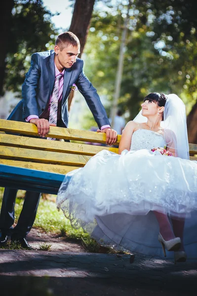 Noiva e noivo no dia do casamento andando ao ar livre na natureza de primavera. Casal nupcial, mulher recém-casada feliz e homem abraçando no parque verde. Casal de amor ao ar livre — Fotografia de Stock