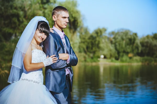 Coppia sposata che si bacia sulla spiaggia del fiume. Sposa sposo coppia matrimonio a piedi all'aperto sulla riva del fiume — Foto Stock