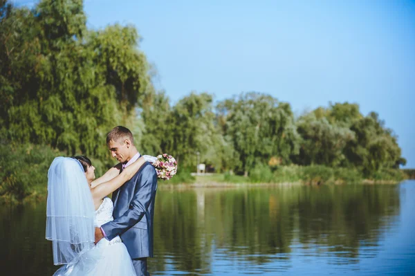 Married couple kissing on river beach. Bride Groom  couple wedding walking Outdoor on rivershore — Stock Photo, Image