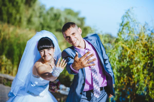 Novia y novio en el día de la boda caminando al aire libre en la naturaleza de primavera. Pareja nupcial, feliz mujer recién casada y hombre abrazándose en el parque verde. Amar pareja de boda al aire libre — Foto de Stock