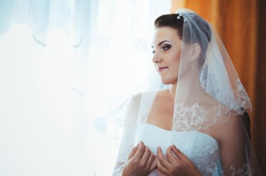 Gelin hazırlanıyor. güzel gelin beyaz düğün elbise parlak makyaj ve saç modeli ile. Damat için bekleyen mutlu seksi kız. Gelin elbiseli romantik Bayan var düğün için son hazırlık ve sunuş