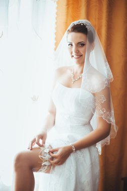 Gelin hazırlanıyor. güzel gelin beyaz düğün elbise parlak makyaj ve saç modeli ile. Damat için bekleyen mutlu seksi kız. Gelin elbiseli romantik Bayan var düğün için son hazırlık ve sunuş