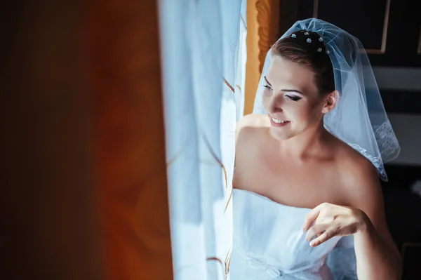 A noiva está a preparar-se. noiva bonita em vestido de noiva branco com penteado e maquiagem brilhante. Menina sexy feliz à espera de noivo. Senhora romântica em vestido de noiva tem preparação final para o casamento — Fotografia de Stock