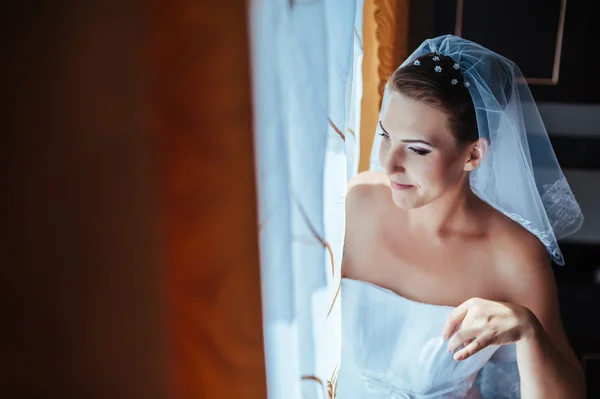 Bride getting ready. beautiful bride in white wedding dress with hairstyle and bright makeup. Happy sexy girl waiting for groom. Romantic lady in bridal dress have final preparation for wedding — Stock Photo, Image