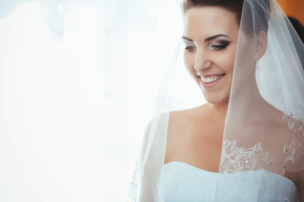 A noiva está a preparar-se. noiva bonita em vestido de noiva branco com penteado e maquiagem brilhante. Menina sexy feliz à espera de noivo. Senhora romântica em vestido de noiva tem preparação final para o casamento — Fotografia de Stock