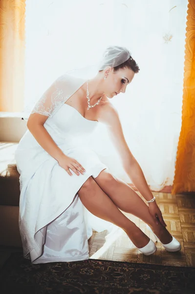 Bride getting ready. beautiful bride in white wedding dress with hairstyle and bright makeup. Happy sexy girl waiting for groom. Romantic lady in bridal dress have final preparation for wedding