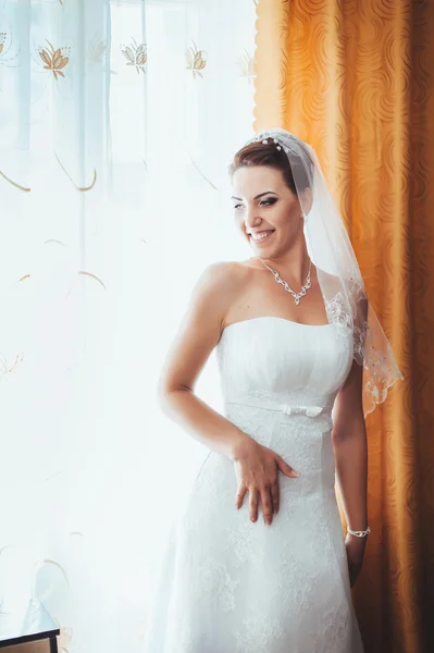 A noiva está a preparar-se. noiva bonita em vestido de noiva branco com penteado e maquiagem brilhante. Menina sexy feliz à espera de noivo. Senhora romântica em vestido de noiva tem preparação final para o casamento — Fotografia de Stock