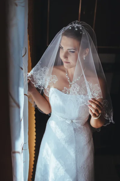 A noiva está a preparar-se. noiva bonita em vestido de noiva branco com penteado e maquiagem brilhante. Menina sexy feliz à espera de noivo. Senhora romântica em vestido de noiva tem preparação final para o casamento — Fotografia de Stock