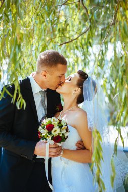 Gelin ve damat, düğün günü açık havada yürüyüş Doğa bahar. mutlu yeni evli kadın ve erkek yeşil park kucaklayan gelin çift. sevgi dolu evlilik çift açık.