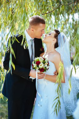 Gelin ve damat, düğün günü açık havada yürüyüş Doğa bahar. mutlu yeni evli kadın ve erkek yeşil park kucaklayan gelin çift. sevgi dolu evlilik çift açık.