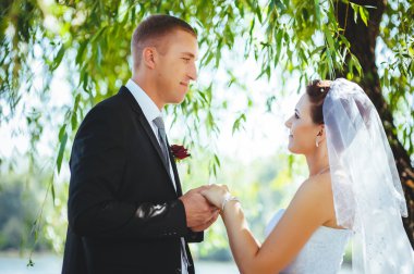 Gelin ve damat, düğün günü açık havada yürüyüş Doğa bahar. mutlu yeni evli kadın ve erkek yeşil park kucaklayan gelin çift. sevgi dolu evlilik çift açık.