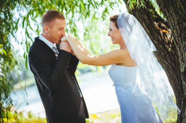 Gelin ve damat, düğün günü açık havada yürüyüş Doğa bahar. mutlu yeni evli kadın ve erkek yeşil park kucaklayan gelin çift. sevgi dolu evlilik çift açık.