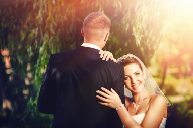 Gelin ve damat, düğün günü açık havada yürüyüş Doğa bahar. mutlu yeni evli kadın ve erkek yeşil park kucaklayan gelin çift. sevgi dolu evlilik çift açık.