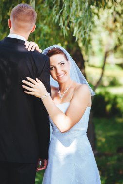 Gelin ve damat, düğün günü açık havada yürüyüş Doğa bahar. mutlu yeni evli kadın ve erkek yeşil park kucaklayan gelin çift. sevgi dolu evlilik çift açık.