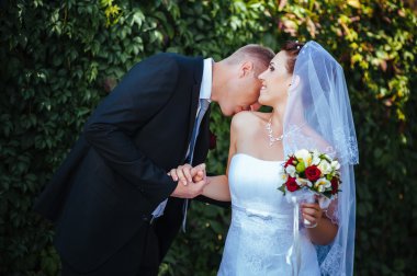 Gelin ve damat, düğün günü açık havada yürüyüş Doğa bahar. mutlu yeni evli kadın ve erkek yeşil park kucaklayan gelin çift. sevgi dolu evlilik çift açık.