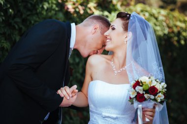 Gelin ve damat, düğün günü açık havada yürüyüş Doğa bahar. mutlu yeni evli kadın ve erkek yeşil park kucaklayan gelin çift. sevgi dolu evlilik çift açık.