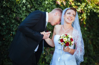 Gelin ve damat, düğün günü açık havada yürüyüş Doğa bahar. mutlu yeni evli kadın ve erkek yeşil park kucaklayan gelin çift. sevgi dolu evlilik çift açık.