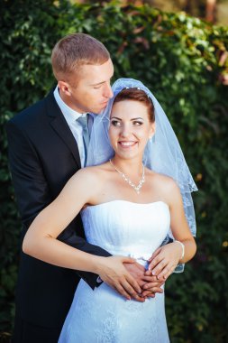 Gelin ve damat, düğün günü açık havada yürüyüş Doğa bahar. mutlu yeni evli kadın ve erkek yeşil park kucaklayan gelin çift. sevgi dolu evlilik çift açık.