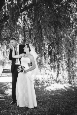 Gelin ve damat, düğün günü açık havada yürüyüş Doğa bahar. mutlu yeni evli kadın ve erkek yeşil park kucaklayan gelin çift. sevgi dolu evlilik çift açık.