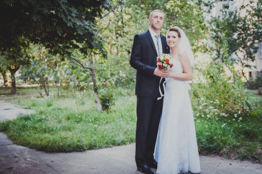 Gelin ve damat, düğün günü açık havada yürüyüş Doğa bahar. mutlu yeni evli kadın ve erkek yeşil park kucaklayan gelin çift. sevgi dolu evlilik çift açık.