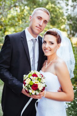 Gelin ve damat, düğün günü açık havada yürüyüş Doğa bahar. mutlu yeni evli kadın ve erkek yeşil park kucaklayan gelin çift. sevgi dolu evlilik çift açık.