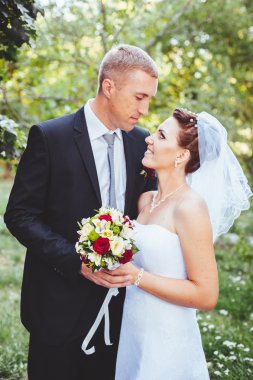 Gelin ve damat, düğün günü açık havada yürüyüş Doğa bahar. mutlu yeni evli kadın ve erkek yeşil park kucaklayan gelin çift. sevgi dolu evlilik çift açık.