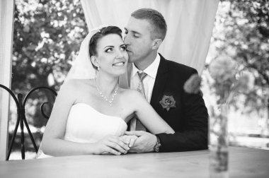 Gelin ve damat parkta süslü Ziyafet masada yaz aylarında poz. Mutluluk ve sevgi bir anın tadını çıkarın. Benim portföy fotoğraf bir dizi