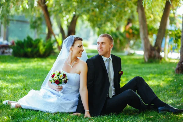 Nevěsty a ženicha na svatební den chůze venku na jarní přírody. Novomanželé, šťastný novomanželský žena a muž objímal v zeleném parku. milující venkovní svatební pár. — Stock fotografie