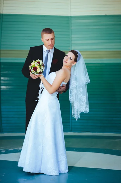 Novia y novio en el día de la boda caminando al aire libre en la naturaleza de primavera. Pareja nupcial, feliz mujer recién casada y hombre abrazándose en el parque verde. Amar pareja de boda al aire libre . — Foto de Stock