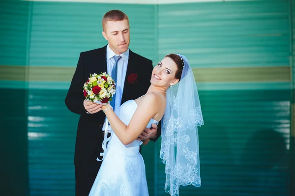 Novia y novio en el día de la boda caminando al aire libre en la naturaleza de primavera. Pareja nupcial, feliz mujer recién casada y hombre abrazándose en el parque verde. Amar pareja de boda al aire libre . — Foto de Stock