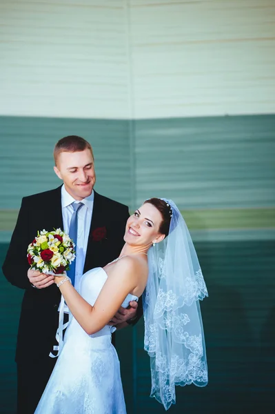 Sposo e Sposo al matrimonio Giorno camminando all'aperto sulla natura primaverile. Coppia di sposi, donna e uomo sposati felici che si abbracciano nel parco verde. Amare coppia di nozze all'aperto . — Foto Stock