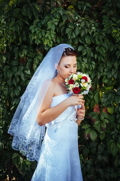 Retrato de bela noiva jovem segurando buquê brilhante de flores em mãos. Celebração de casamento. recepção. natureza fundo verde. mulher sozinha ao ar livre no parque — Fotografia de Stock